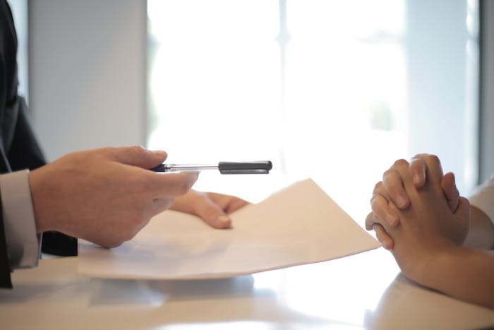 leasing agent handing pen to tenant to sign lease