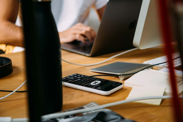 An accountant with a laptop and computer using QuickBooks software for their rental property operations